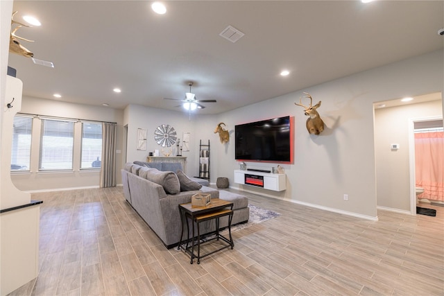 living room with ceiling fan and light hardwood / wood-style floors