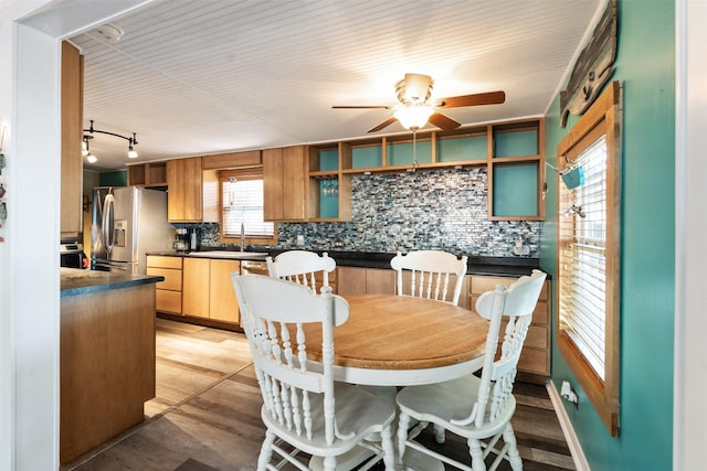 dining area with ceiling fan, track lighting, sink, and light wood-type flooring