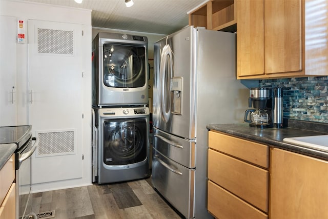 laundry area with stacked washer / drying machine and dark hardwood / wood-style floors