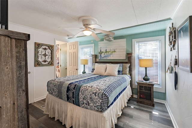 bedroom featuring dark hardwood / wood-style flooring, ceiling fan, and a textured ceiling