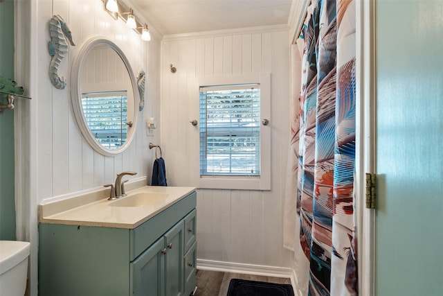 full bathroom with shower / tub combo, vanity, wood-type flooring, ornamental molding, and toilet