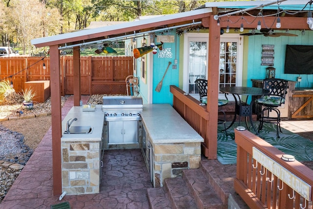 view of patio with ceiling fan, an outdoor kitchen, grilling area, and sink