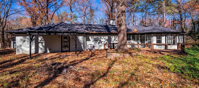 rear view of property featuring a sunroom