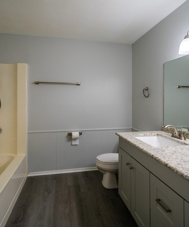 bathroom featuring wood-type flooring, toilet, and vanity