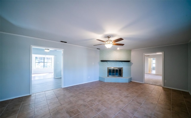 unfurnished living room featuring crown molding, a brick fireplace, tile patterned floors, and ceiling fan