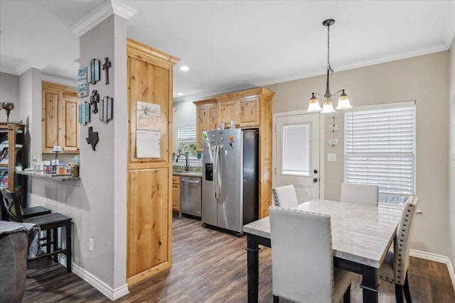 dining space featuring crown molding, sink, a notable chandelier, and dark hardwood / wood-style flooring