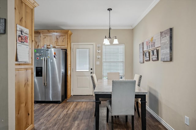 dining area featuring ornamental molding, an inviting chandelier, and dark hardwood / wood-style flooring