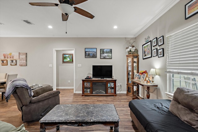 living room featuring crown molding, wood-type flooring, and ceiling fan