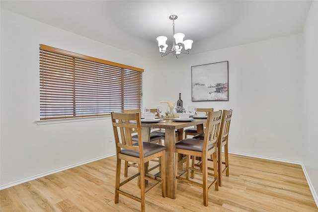 dining space with a notable chandelier and light wood-type flooring