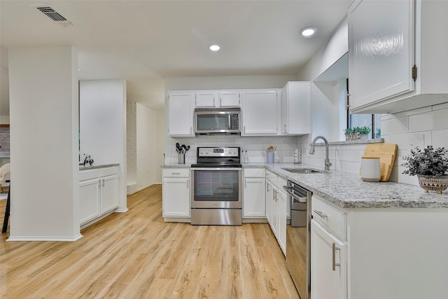 kitchen featuring sink, stainless steel appliances, and white cabinets