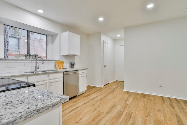 kitchen featuring white cabinetry, sink, backsplash, stainless steel dishwasher, and light stone countertops