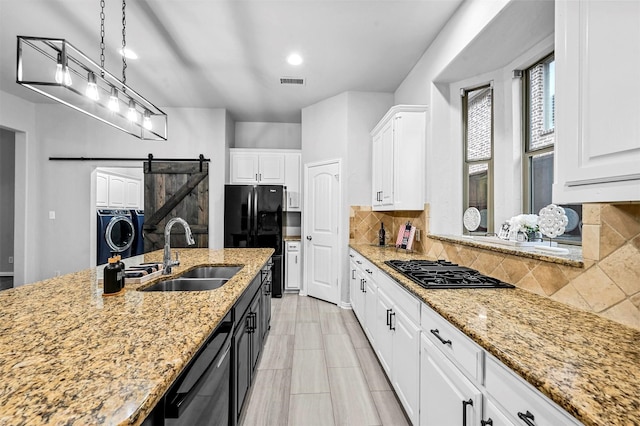 kitchen with pendant lighting, sink, a barn door, and white cabinets