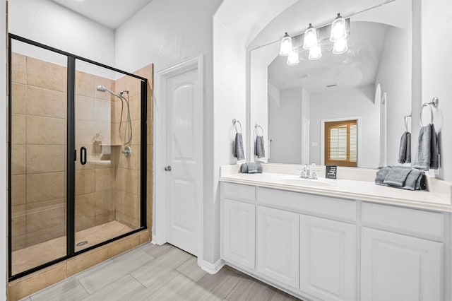 bathroom with walk in shower and vanity