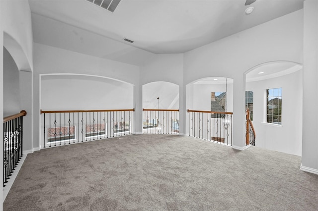 carpeted spare room with vaulted ceiling