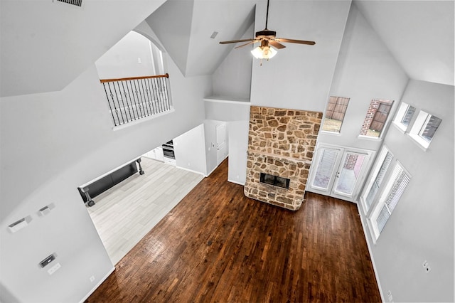 living room with a stone fireplace, high vaulted ceiling, dark hardwood / wood-style floors, and ceiling fan