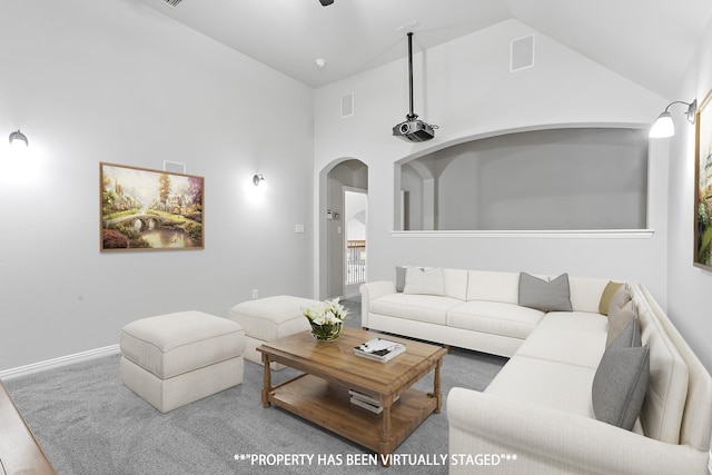 living room with high vaulted ceiling and carpet flooring