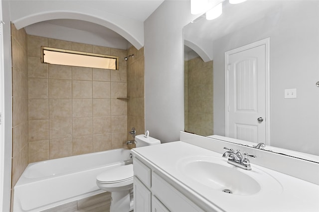 full bathroom with vanity, tiled shower / bath combo, and toilet