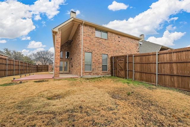 rear view of house with a patio and a lawn