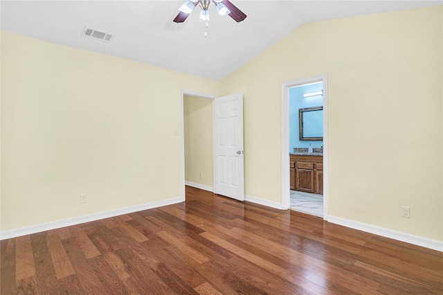 unfurnished bedroom with vaulted ceiling, ensuite bath, ceiling fan, and hardwood / wood-style floors