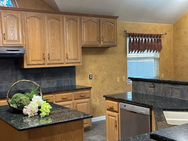 kitchen with range hood, decorative backsplash, stainless steel dishwasher, and dark stone countertops