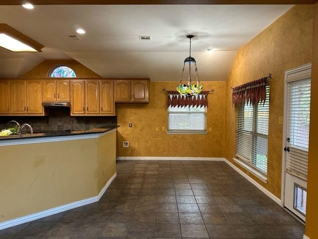 kitchen featuring pendant lighting, vaulted ceiling, and tasteful backsplash