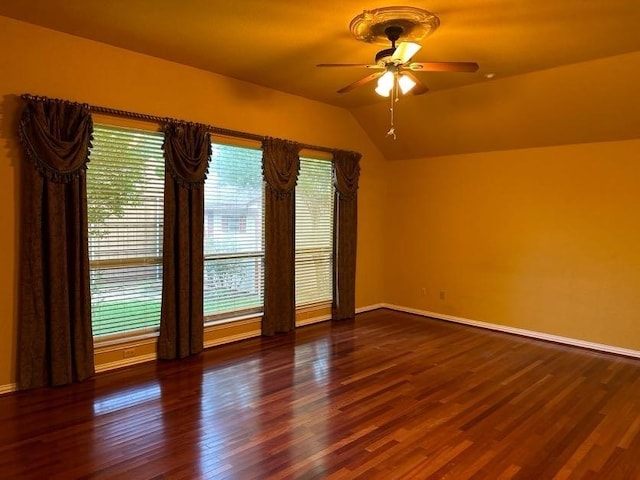 spare room with vaulted ceiling, dark hardwood / wood-style floors, and ceiling fan