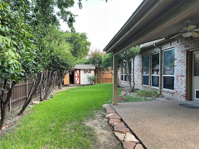 view of yard with a patio, ceiling fan, and a storage unit