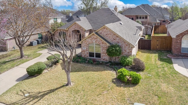 3108 Fernhurst Dr, Richardson, TX 75082 - french country style house featuring a front lawn, a gate, central air condition unit, fence, and a shingled roof