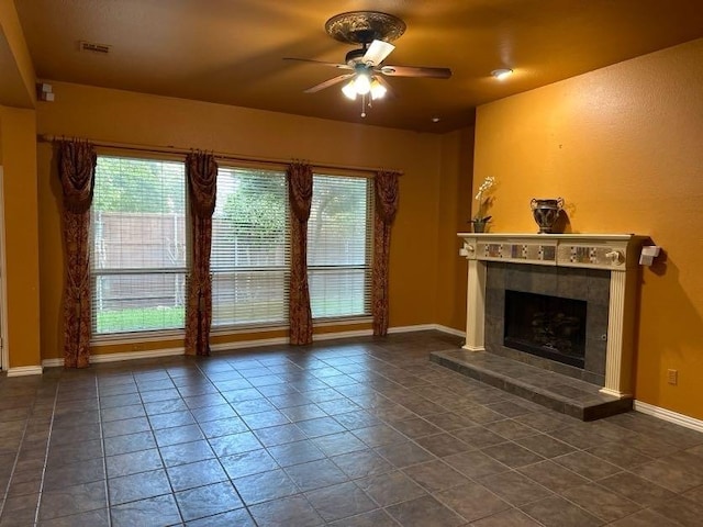 unfurnished living room with ceiling fan and a fireplace