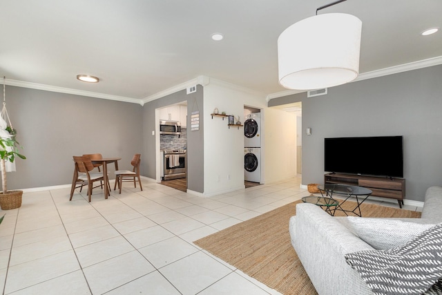 living room featuring light tile patterned floors, crown molding, and stacked washer and clothes dryer