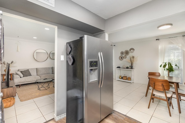 kitchen featuring light tile patterned flooring, crown molding, and stainless steel fridge with ice dispenser