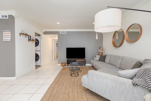 tiled living room with stacked washer / dryer and crown molding