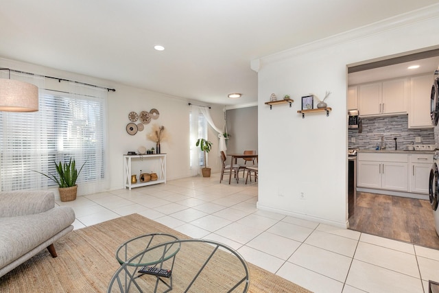 living room featuring sink, ornamental molding, and light tile patterned flooring