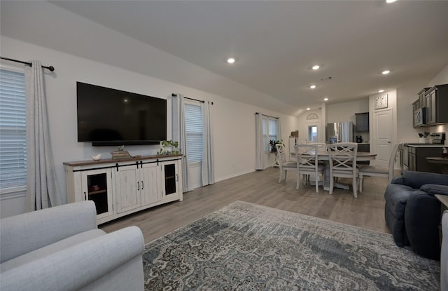 living room with vaulted ceiling and light hardwood / wood-style flooring