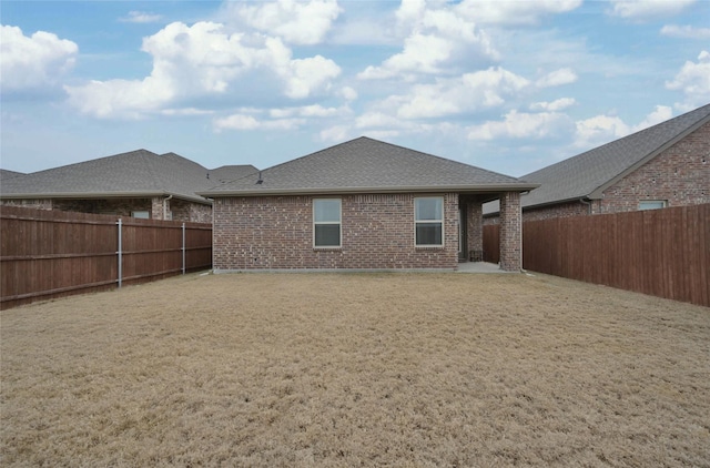 rear view of house featuring a yard