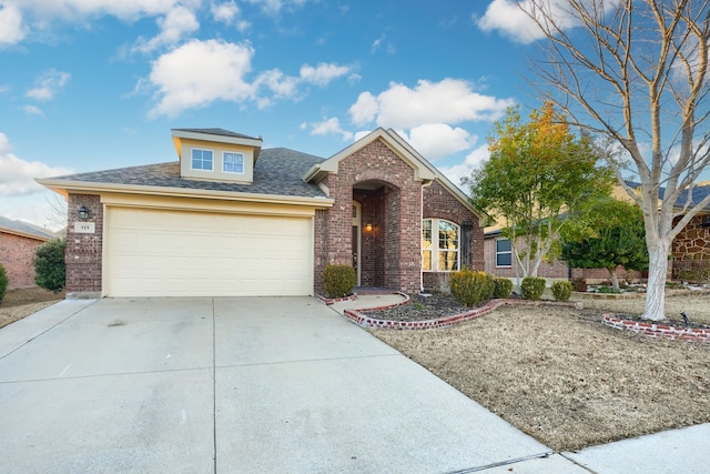 view of front facade with driveway, brick siding, an attached garage, and a shingled roof