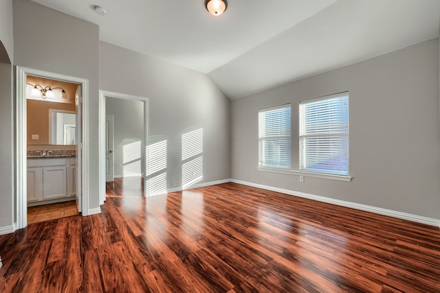 interior space with lofted ceiling, hardwood / wood-style flooring, and ensuite bath