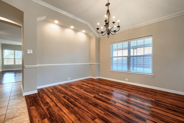 spare room with ornamental molding, lofted ceiling, hardwood / wood-style floors, and a chandelier