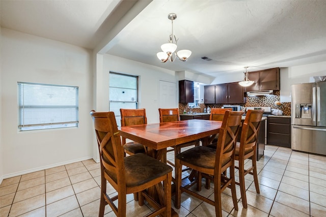 dining room featuring light tile patterned floors, a notable chandelier, and a wealth of natural light