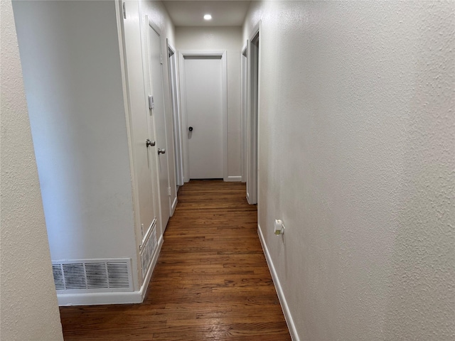 corridor with dark hardwood / wood-style flooring