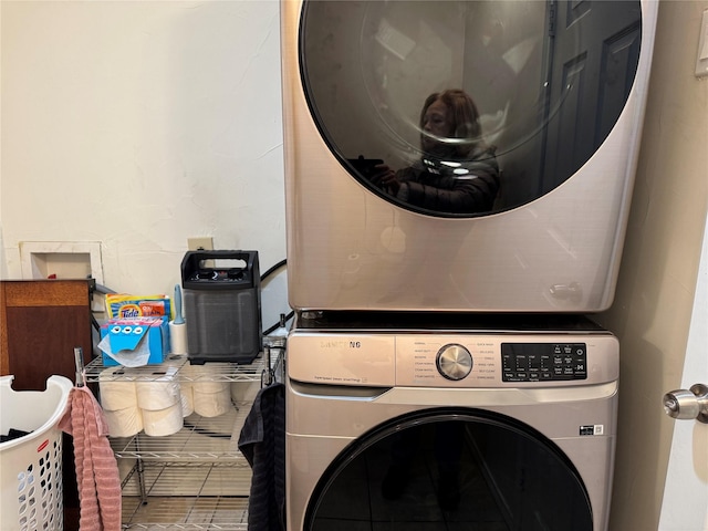 laundry area featuring stacked washer / drying machine