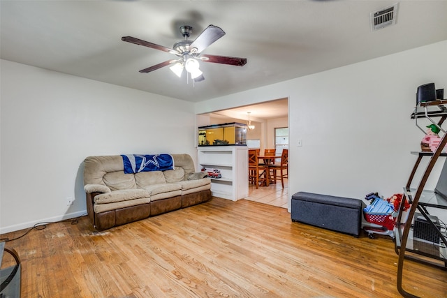 living room with ceiling fan and light hardwood / wood-style flooring