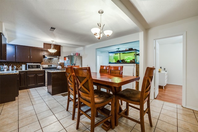 tiled dining room featuring a chandelier