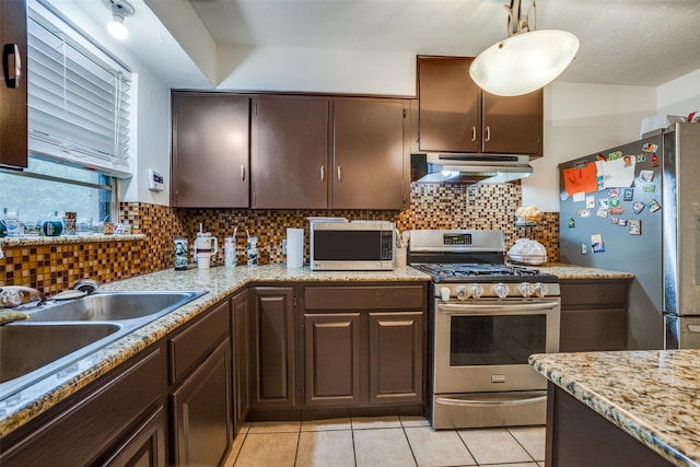 kitchen featuring pendant lighting, backsplash, dark brown cabinetry, and appliances with stainless steel finishes