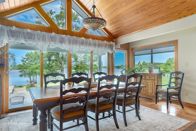 sunroom / solarium featuring a water view, vaulted ceiling, and a wealth of natural light