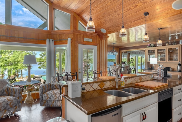 kitchen with pendant lighting, sink, dishwasher, a water view, and white cabinets