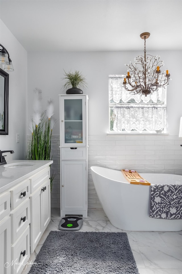 bathroom featuring vanity, a bath, and tile walls