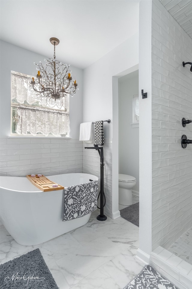 bathroom with a tub to relax in and toilet