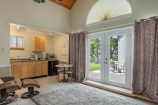 doorway featuring light tile patterned flooring, high vaulted ceiling, sink, and french doors