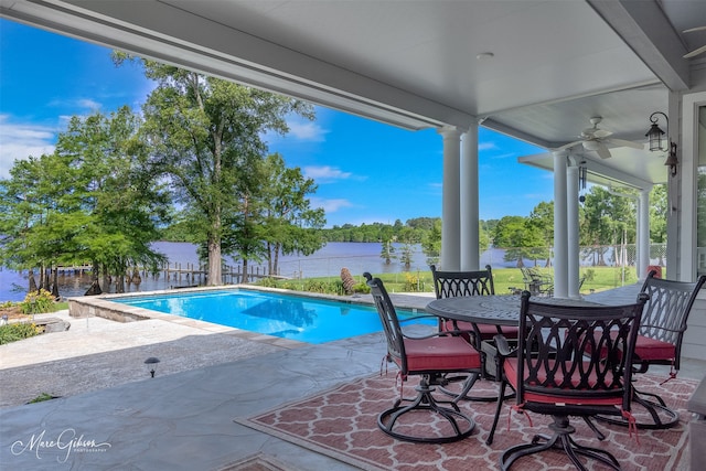 view of swimming pool featuring a patio area, ceiling fan, and a water view